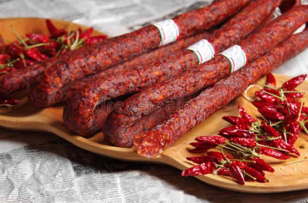 sausage-hungarian-red-paprika-specialities-sausages-dried-wooden-plate-newspaper-background-53477187.jpg